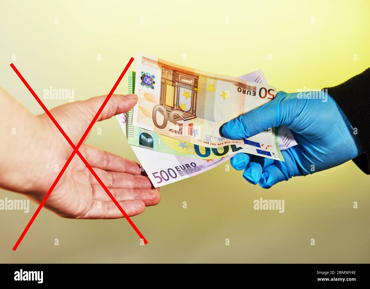 Mano di un uomo in un guanto medico blu dà soldi a una donna senza un guanto sotto forma di euro Notes.IT è vietato prendere soldi senza Foto Stock