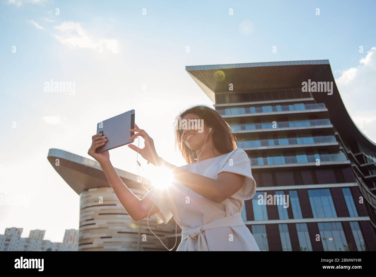 Donna che effettua una videochiamata tramite un tablet per computer in una grande città Foto Stock