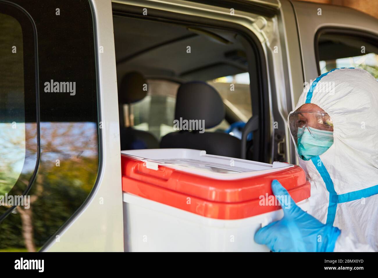 Trasporto e consegna di donazione di organi da parte di medici professionisti in indumenti protettivi durante una pandemia di coronavirus Foto Stock