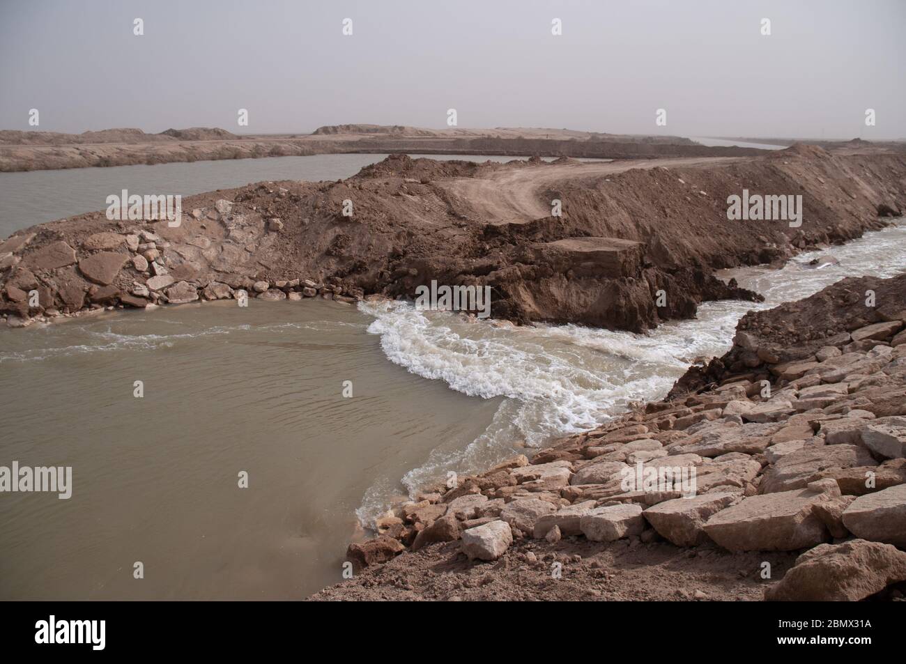 L'acqua scorre attraverso una diga infranto nell'Iraq meridionale, la diga è stata costruita da Saddam Hussein per impedire che l'acqua fluisca attraverso le paludi nell'Iraq meridionale dopo la fine della guerra del Golfo 1 nel 1991, dal fiume Tigri al nord, l'Eufrate al sud. La diga fu violata dopo la caduta di Saddam nel quadro di un progetto di restauro per ribonare le paludi nel 2010 Foto Stock