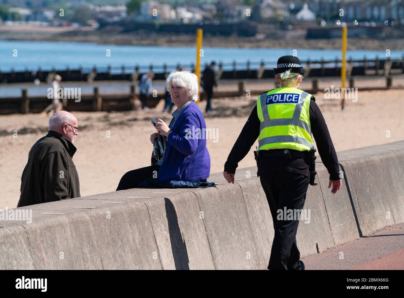 Portobello, Scozia, Regno Unito. 11 maggio 2020. La polizia pattuglia la passeggiata e la spiaggia a Portobello questo pomeriggio in caldo sole tempo. Hanno parlato con il pubblico che era seduto sulla spiaggia o sulla parete di mare chiedendo loro di continuare a muoversi. Nella foto, anche agli anziani è stato chiesto di muoversi. Iain Masterton/Alamy Live News Foto Stock