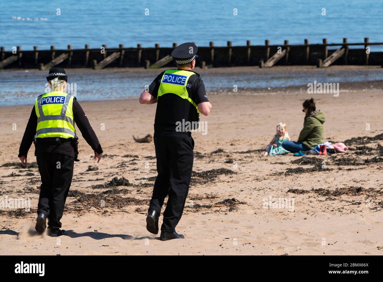 Portobello, Scozia, Regno Unito. 11 maggio 2020. La polizia pattuglia la passeggiata e la spiaggia a Portobello questo pomeriggio in caldo sole tempo. Hanno parlato con il pubblico che era seduto sulla spiaggia o sulla parete di mare chiedendo loro di continuare a muoversi. Iain Masterton/Alamy Live News Foto Stock