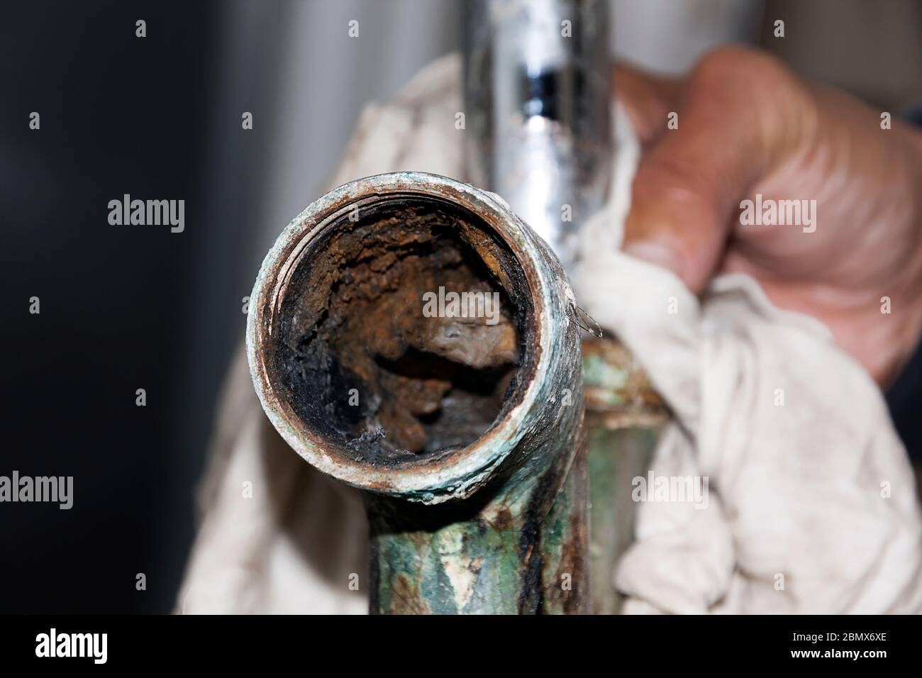 Interno di un tubo del lavandino della stanza da bagno corroso come risultato di età, acqua dura e depositi di calcio. Foto Stock