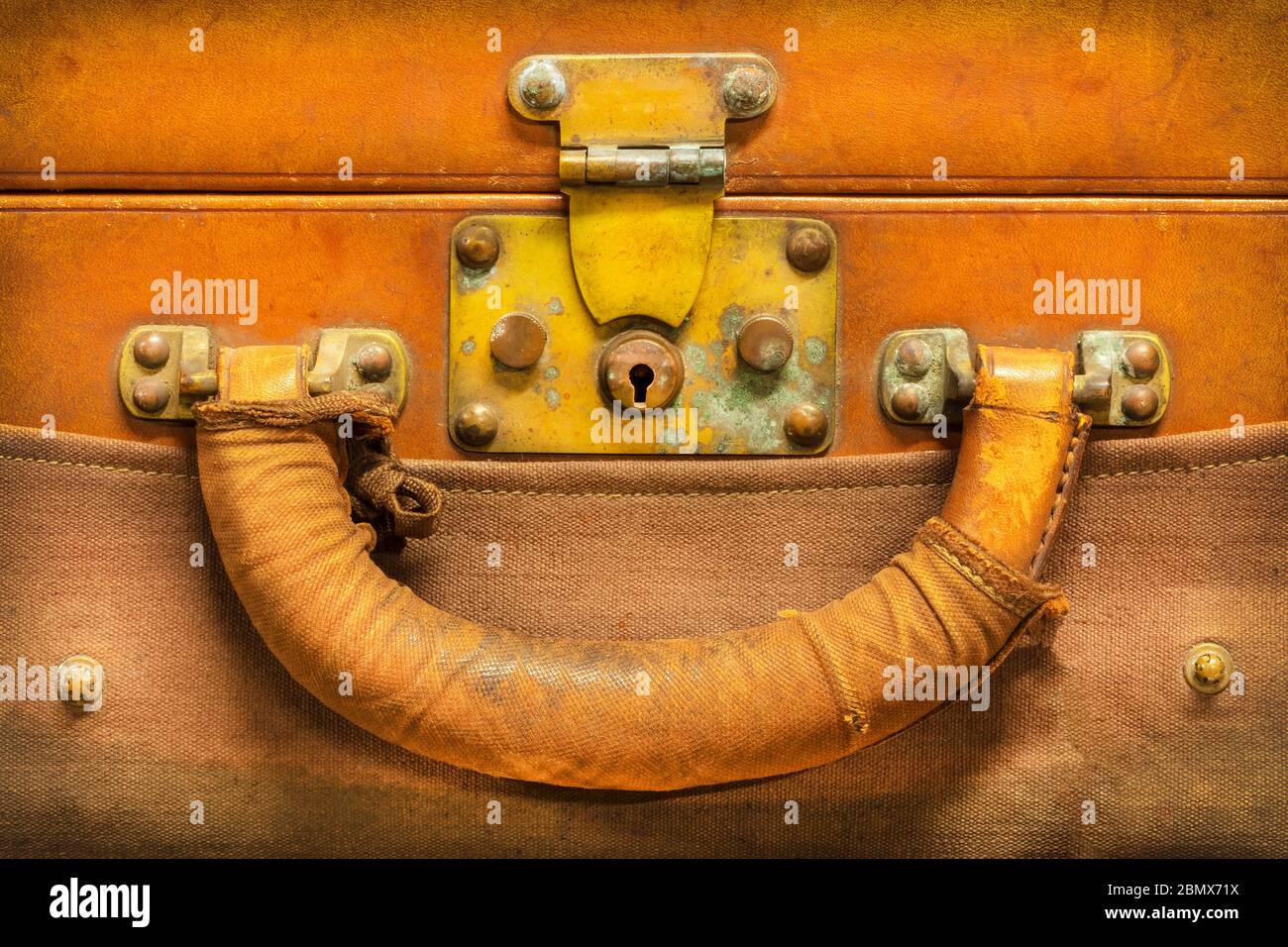 Primo piano di una valigia in pelle marrone intemperata vintage con serratura e manico Foto Stock