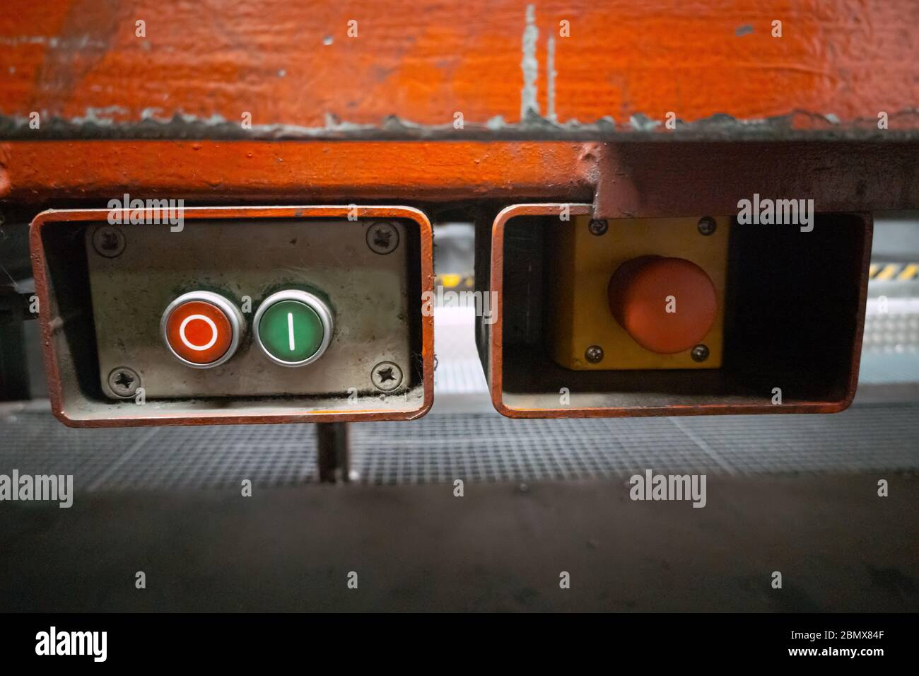 Scatola in metallo con pulsanti di avviamento e arresto e interruttore di emergenza sulla linea di produzione del trasportatore Foto Stock