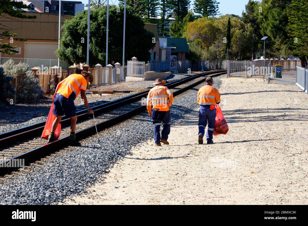 Gruppo di lavoro di 3 uomini che rimuovono rifiuti dalla linea ferroviaria, Fremantle, Australia Occidentale Foto Stock