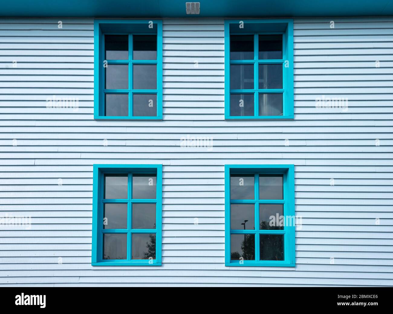 Esterno di una casa in legno dipinto di blu con finestre a sash Foto Stock