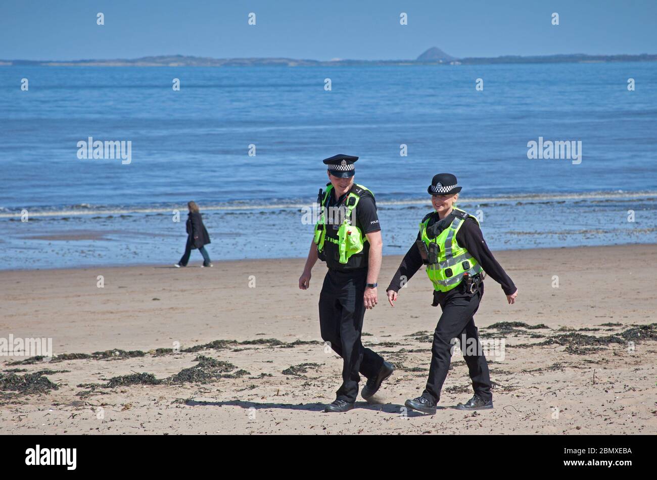 Portobello Beach, Edimburgo, Scozia, Regno Unito.11 Maggio 2020. Polizia pattuglia da quattro ufficiali amichevoli tre maschi e una femmina sul mare abbastanza tranquillo, Avendo chiacchierato con le poche persone che erano seduti sulla spiaggia sabbiosa o sul muro della passeggiata consigliando che potrebbero contrarre il Coronavirus da superfici che toccano mentre sono al mare e consigliando loro di muoversi lungo e prendere il loro excercise permesso mentre fuori e circa. Credit: Arch White/Alamy Live News Foto Stock