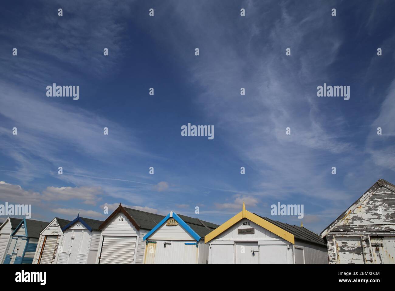 Una fila di capanne sulla spiaggia a Thorpe Bay, vicino a Southend-on-Sea, Essex. Foto Stock