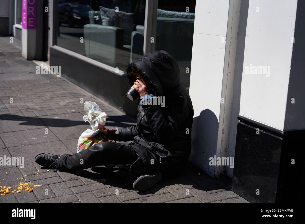 Una persona senza tetto si sedette per strada nella città di Dublino, Irlanda. Foto Stock