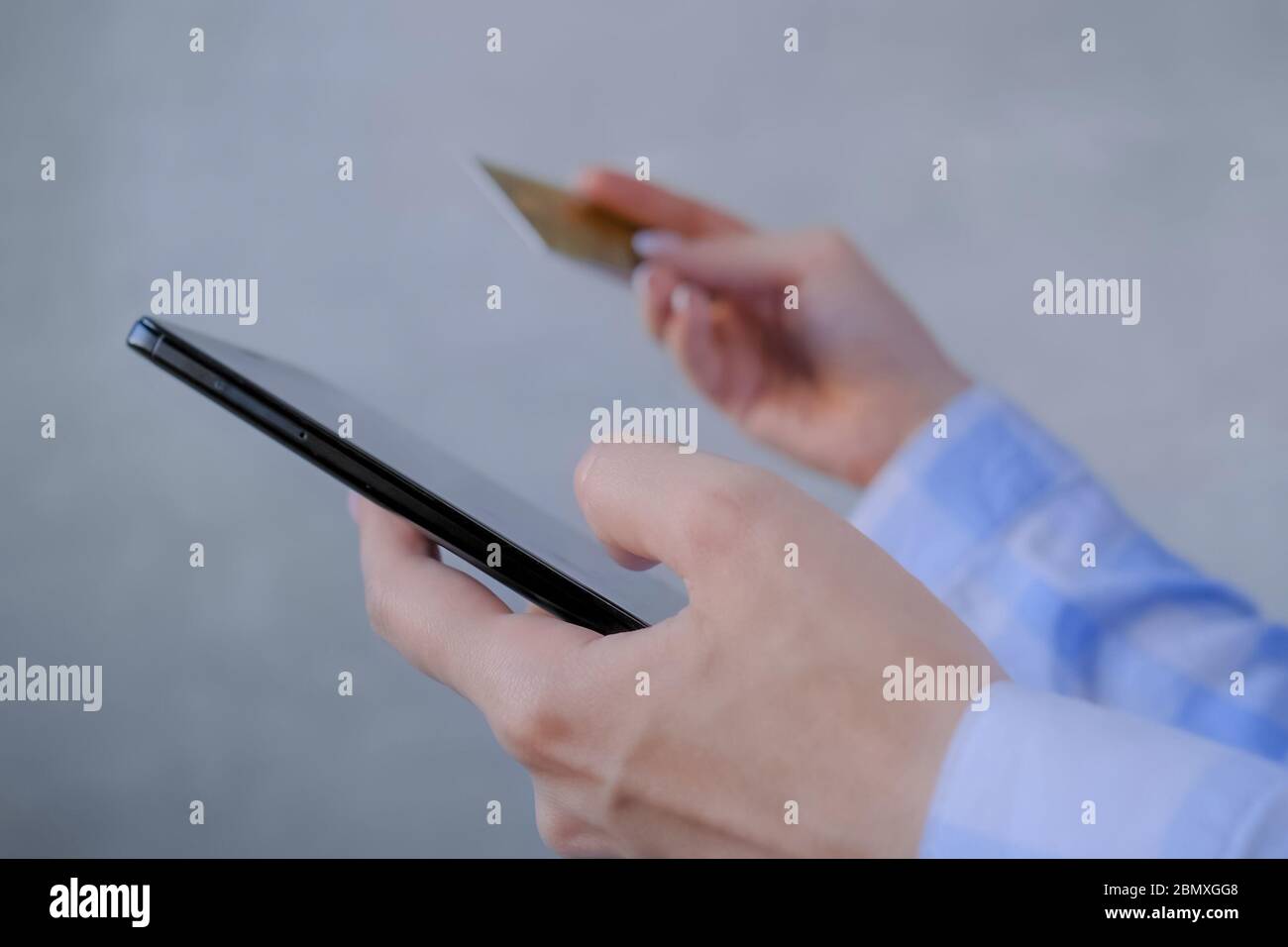 Shopping online, e-commerce, vendita, consumismo, pagamento elettronico, concetto di tecnologia. Donna che utilizza un dispositivo mobile nero con smartphone, che detiene credito Foto Stock