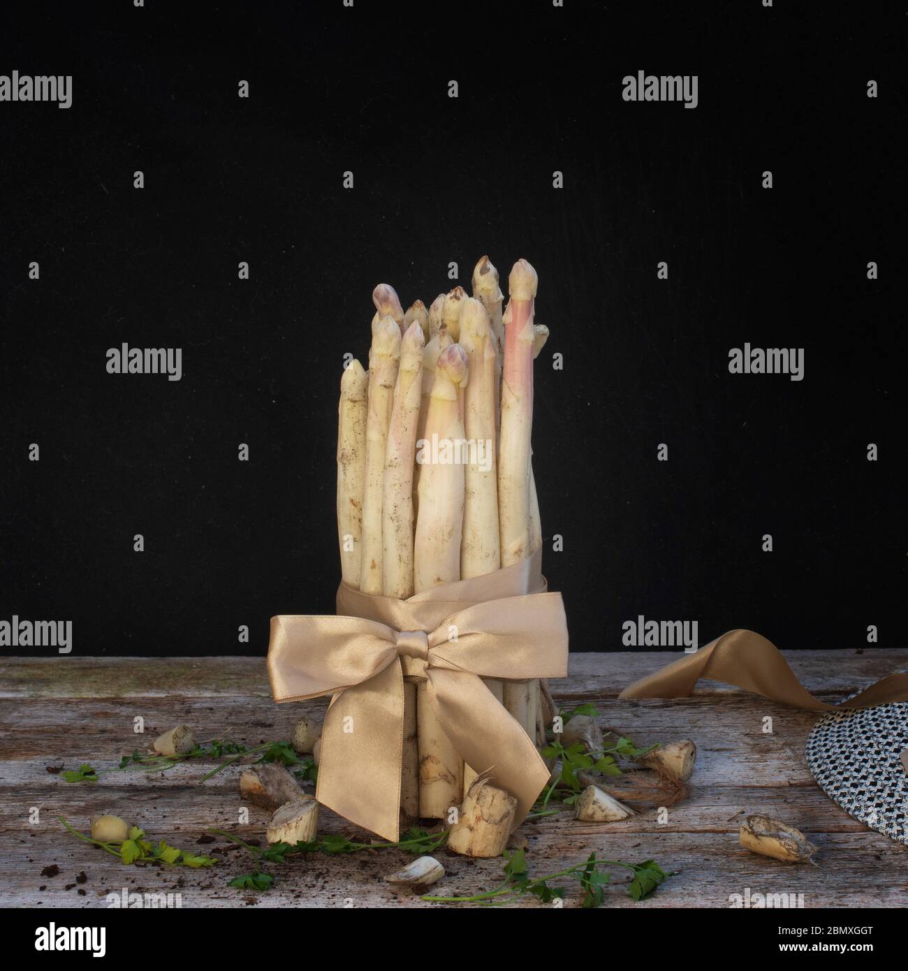 asparagi bianchi vista laterale su tavolo di legno con fondo nero Foto Stock