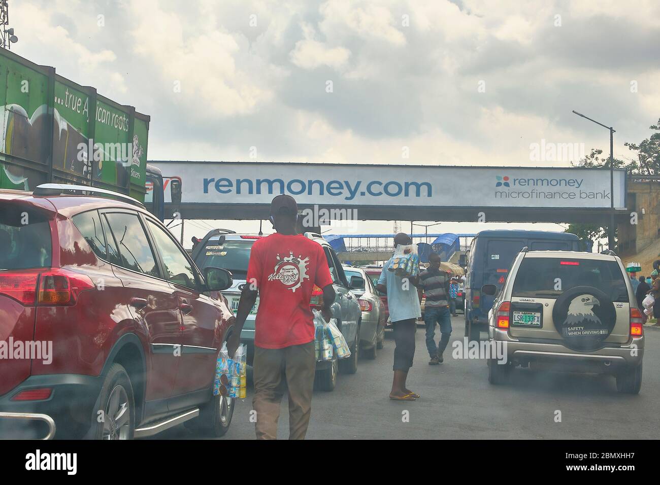 I falchi vendono le loro merci in un traffico lento in movimento a Lagos, Nigeria. Foto Stock