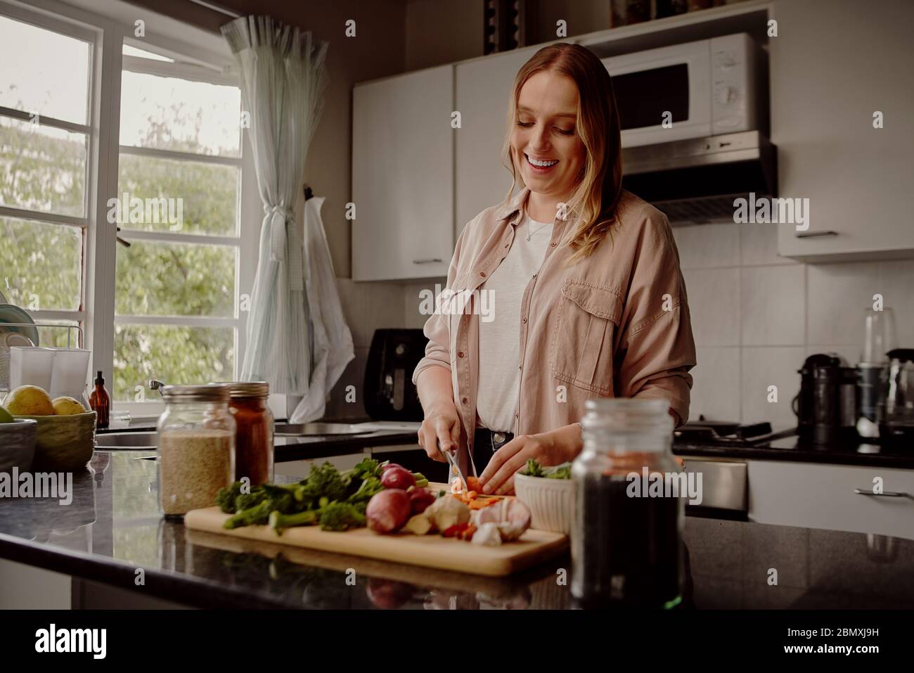 Donna che cucina insalata vegetale estiva in cucina - cucinare un sano pasto vegano a casa Foto Stock