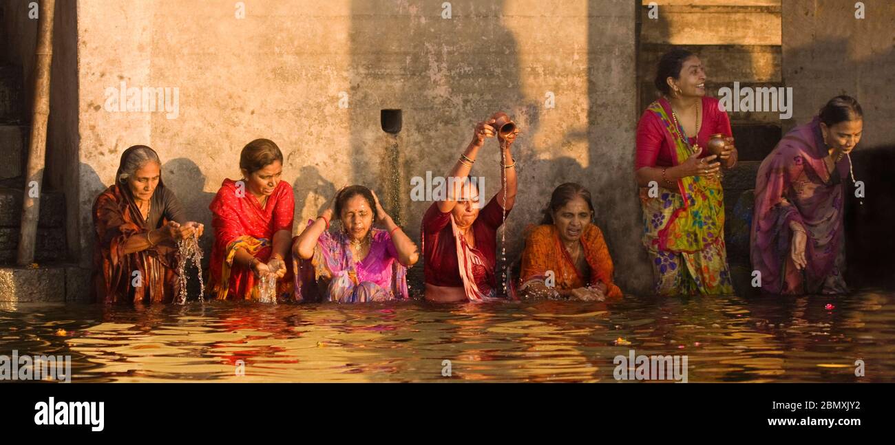 Le Signore indiane che bagnano nel fiume Gange a Varanasi, India Foto Stock