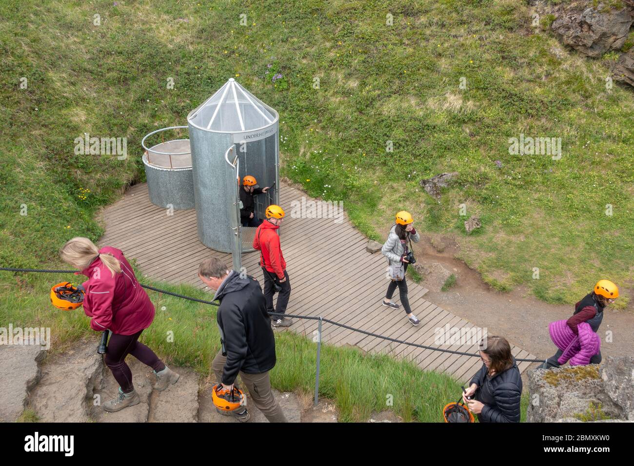 Visitatori intorno alla scala a chiocciola ingresso alla grotta Vatnshellir, un tubo di lava sulla penisola di Snaefellsnes, Islanda occidentale. Foto Stock