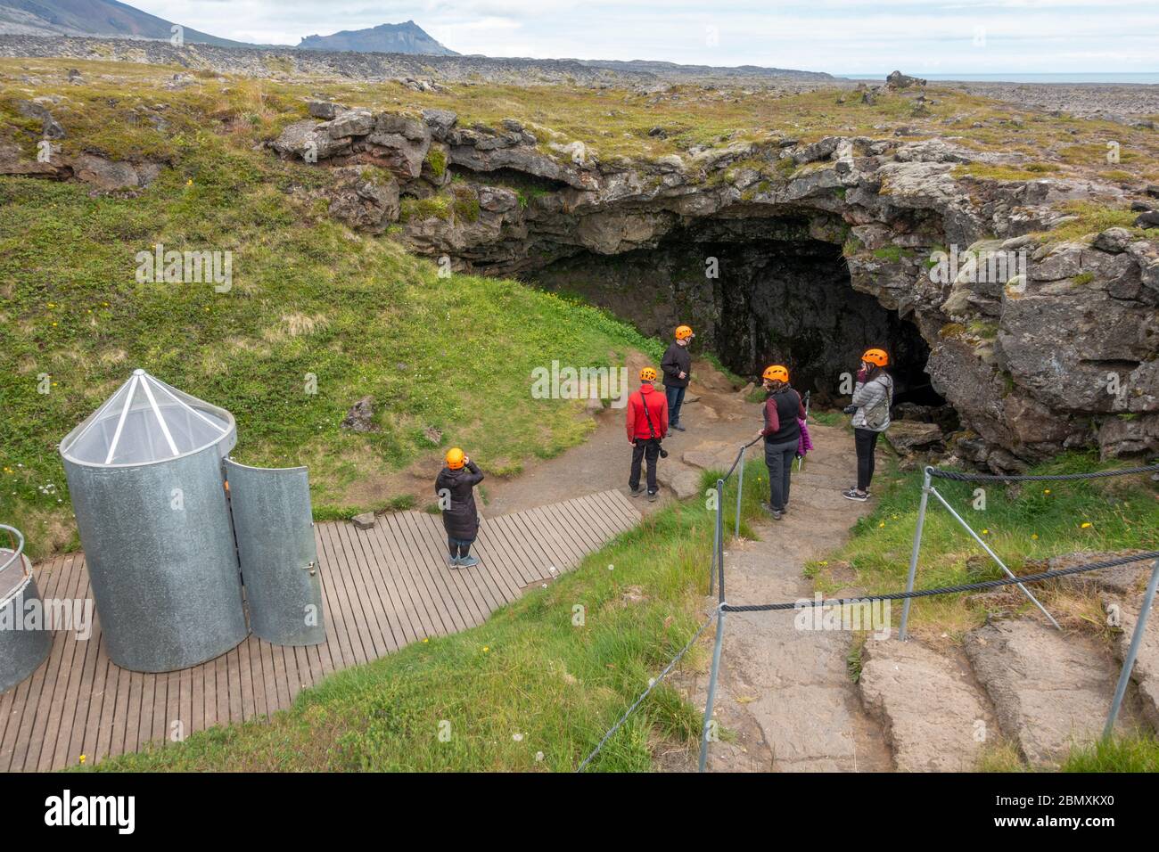 Visitatori intorno alla scala a chiocciola ingresso alla grotta Vatnshellir, un tubo di lava sulla penisola di Snaefellsnes, Islanda occidentale. Foto Stock