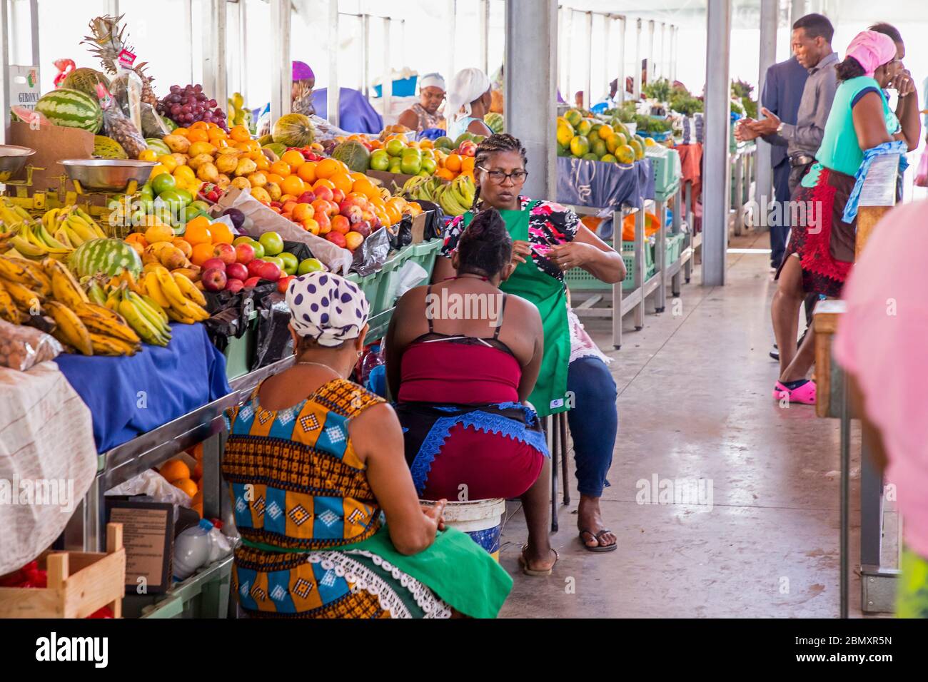 Stand con venditori femminili di Capo Verdean che vendono frutta fresca al mercato alimentare indoor nella città di Praia sull'isola di Santiago, Capo Verde / Cabo Verde Foto Stock