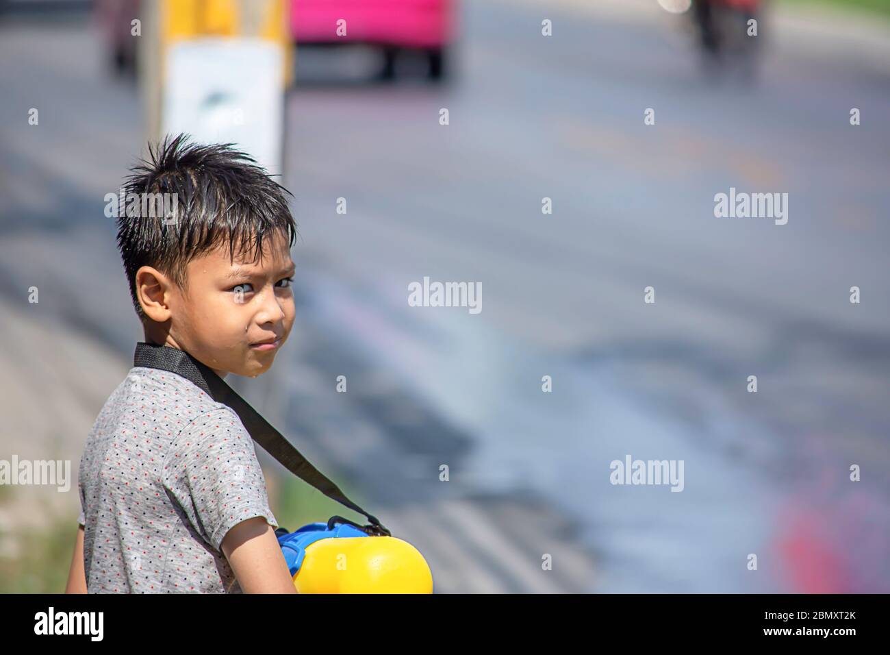 Ragazzo asiatico in possesso di una pistola ad acqua giocare Songkran festival tailandese o il nuovo anno in Thailandia. Foto Stock