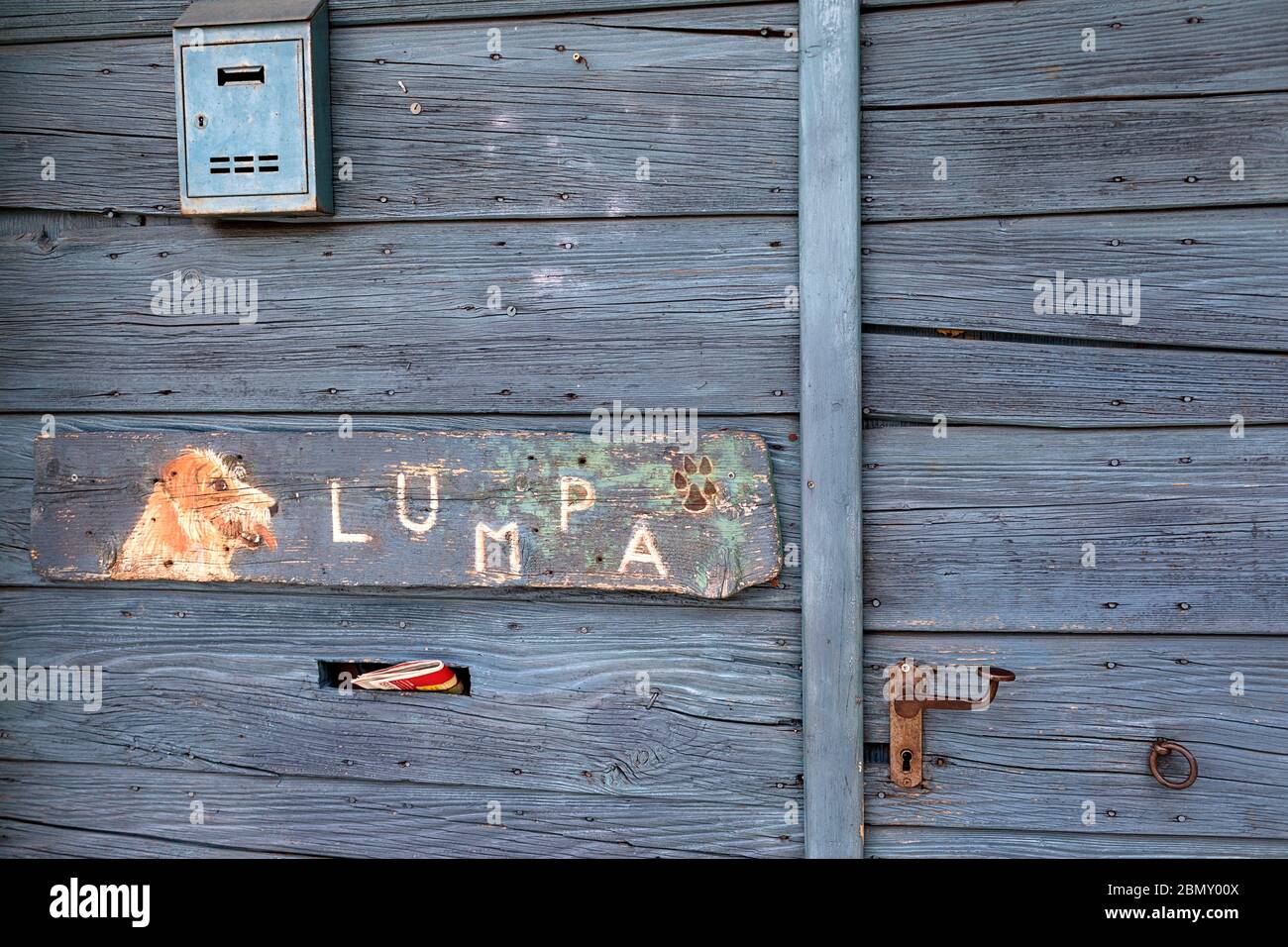 Divertente segno del cane sulla porta di ingresso in legno blu Foto Stock