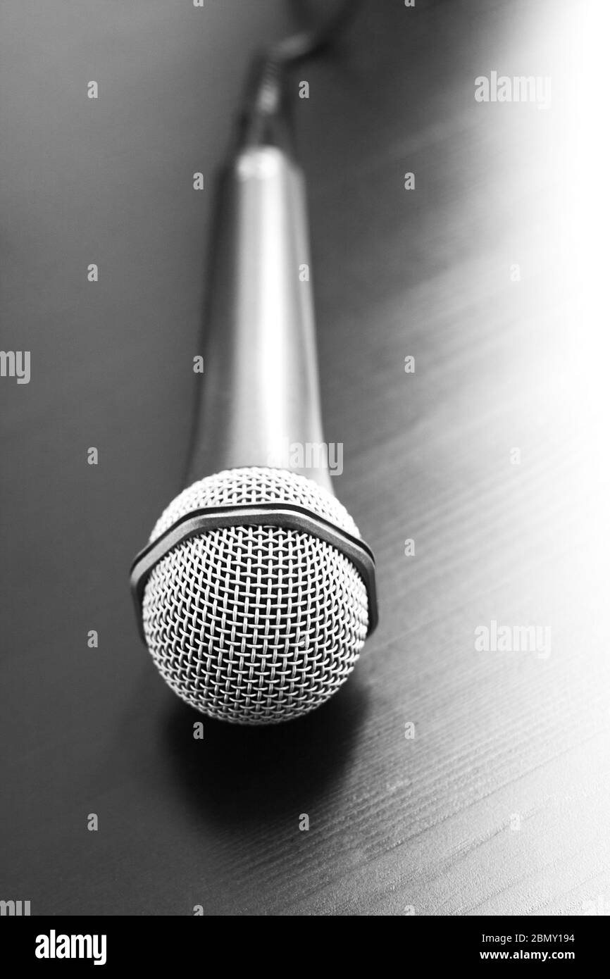Microfono moderno in argento con cavo su sfondo nero. Primo piano. Concetto di altoparlante Foto Stock
