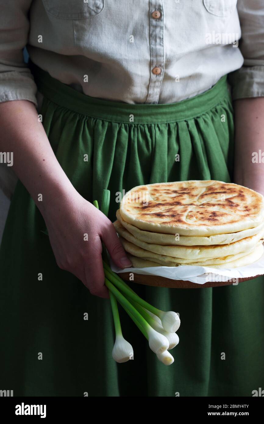 Donna che tiene nelle sue mani tradizionali in diversi paesi torte ripieni di formaggio ed erbe e aglio fresco. Foto Stock