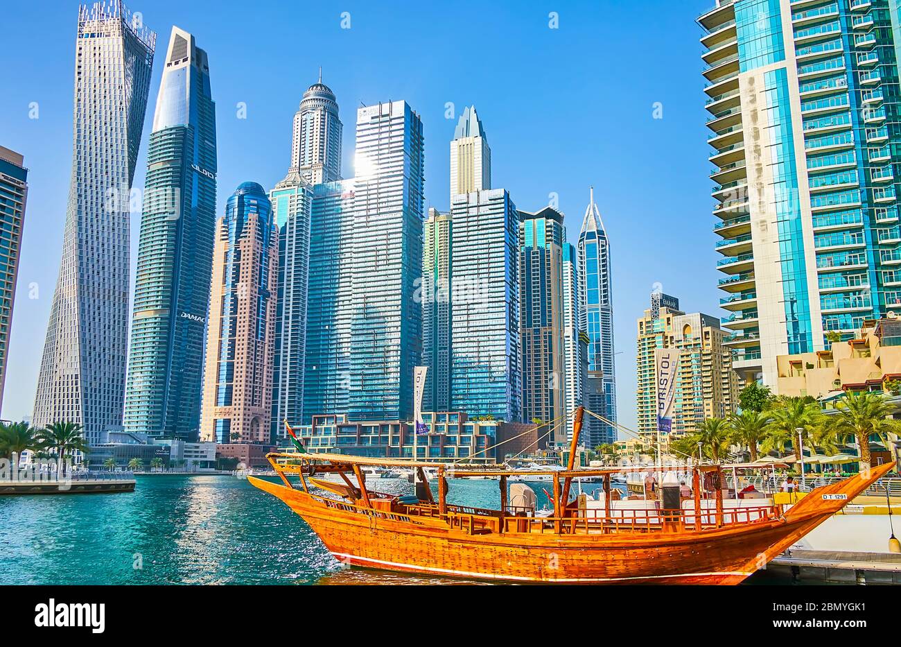 DUBAI, Emirati Arabi Uniti - 2 MARZO 2020: La fusione di tecnologie moderne e stile di vita tradizionale a Dubai Marina - la barca d'epoca in dhow di legno di fronte al Foto Stock