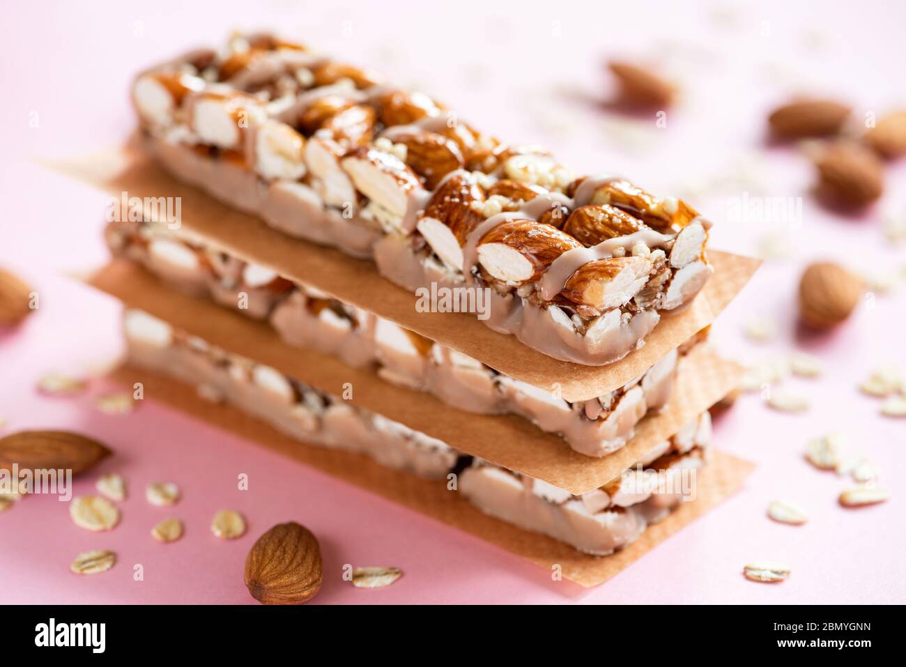 Barre di proteine di mandorle su sfondo rosa. Vista in primo piano. Cibo sano, sport, fitness, snack menu Foto Stock
