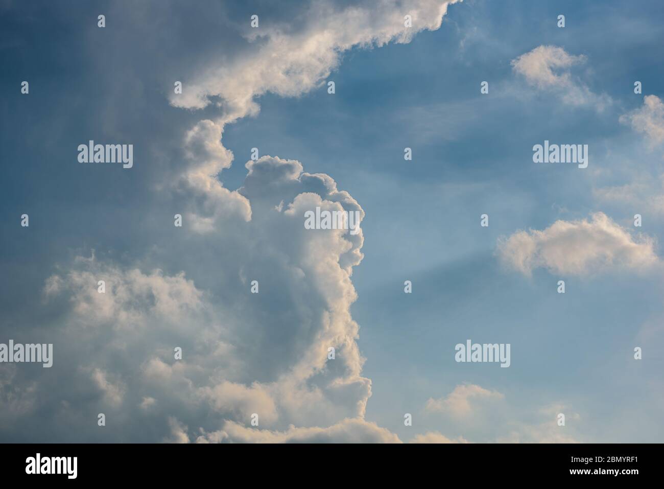 cielo blu pastello con paesaggi e raggi di luce, formato paesaggio con spazio di copia sul lato destro Foto Stock