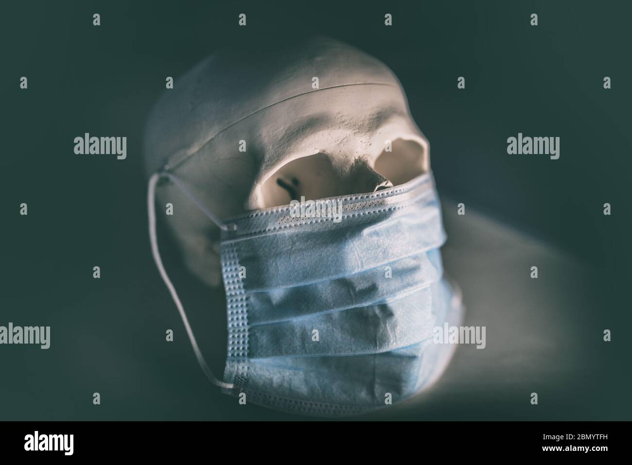 COVID-19 cranio con maschera medica facciale. Concetto di morte del coronavirus Foto Stock