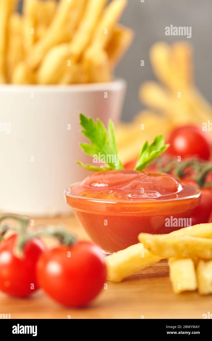 Patatine fritte con ketchup su sfondo di legno. Primo piano. Foto Stock