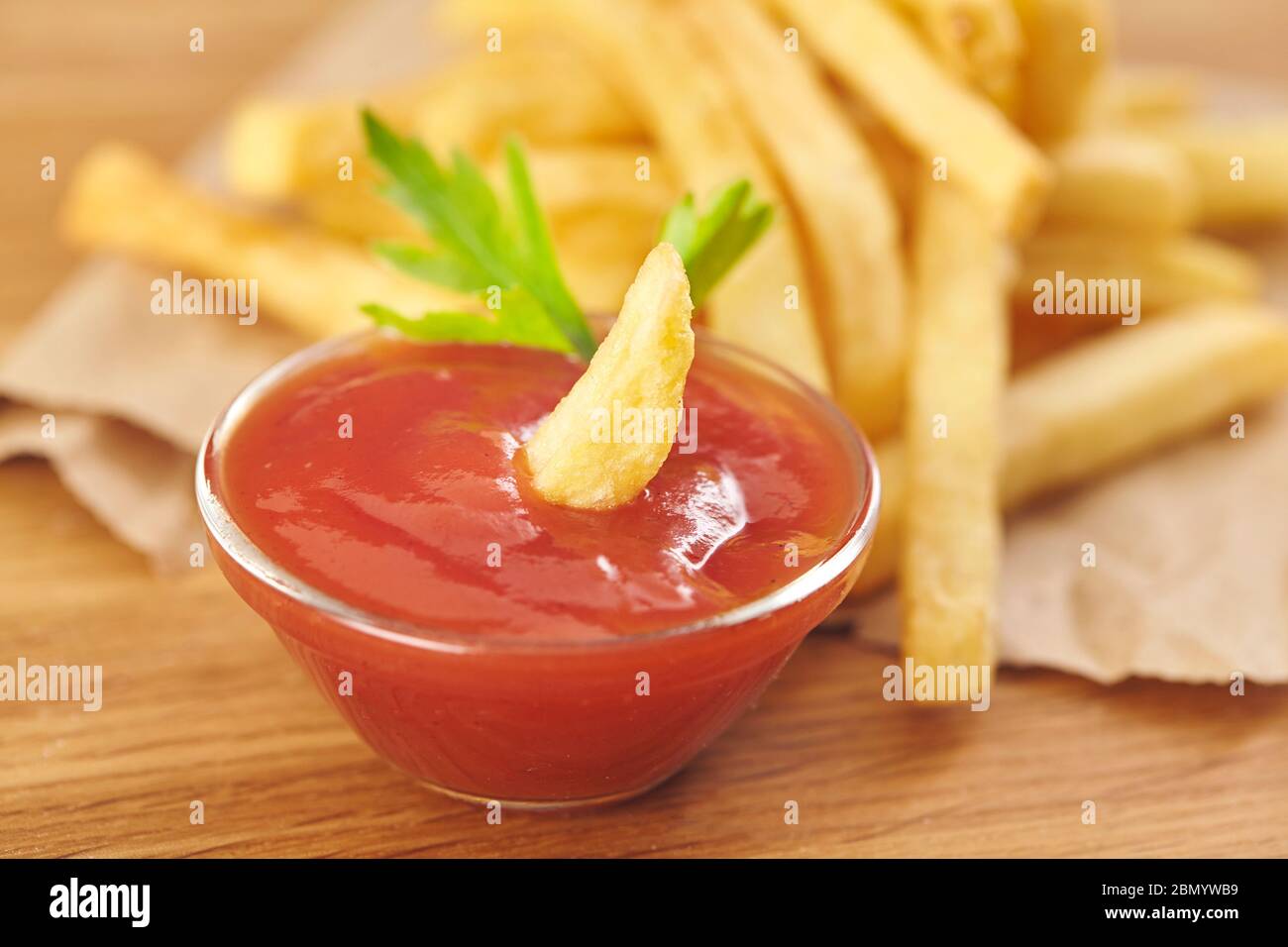 Patatine fritte con ketchup su sfondo di legno. Primo piano. Foto Stock