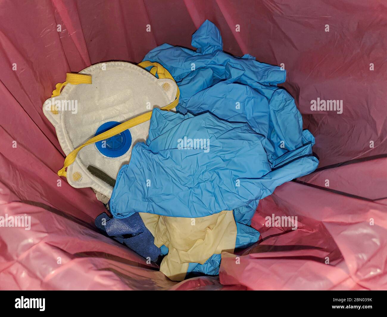 Maschera protettiva e guanti sporchi per uso medico nel cestino dei rifiuti, articoli per l'apparecchiatura per la malattia di coronavirus Foto Stock