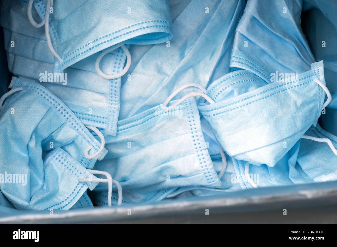 Sfondo delle maschere mediche protettive usate. Mascherine blu dopo l'uso. Maschere mediche che utilizzano. Utilizzo di maschere usate. Foto Stock