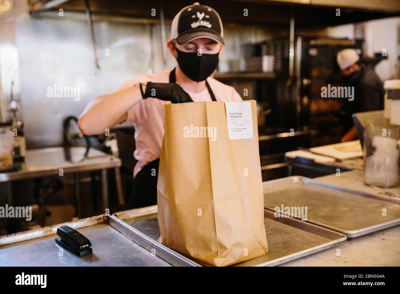 Il ristorante locale si adatta ai tempi di cambiamento con un personale limitato seguendo i protocolli COVID per il servizio di prelievo del cibo che stanno offrendo alla comunità. Foto Stock