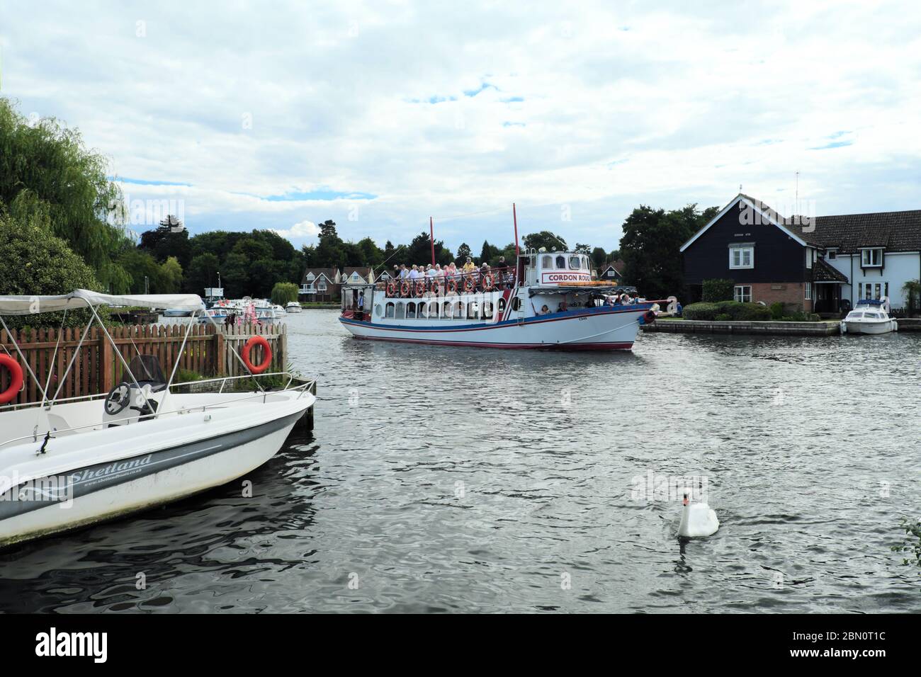 I passeggeri del Cordon Rouge si godono un viaggio lungo i Broads a Wroxham a Norfolk, Inghilterra, Regno Unito Foto Stock