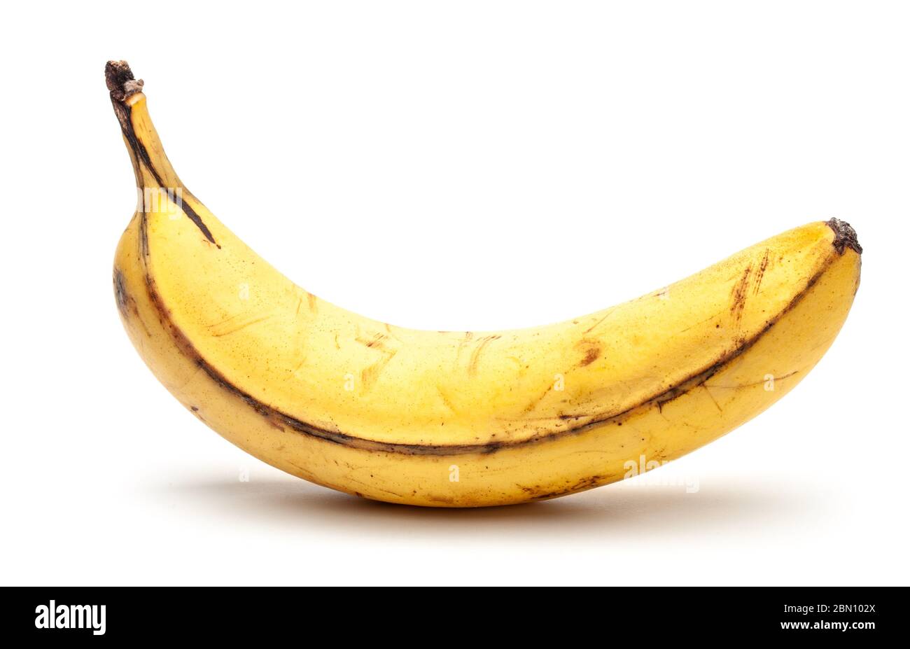 Banana vecchia surmatura. Banana gialla con punti neri. Isolato su uno sfondo bianco. Foto Stock