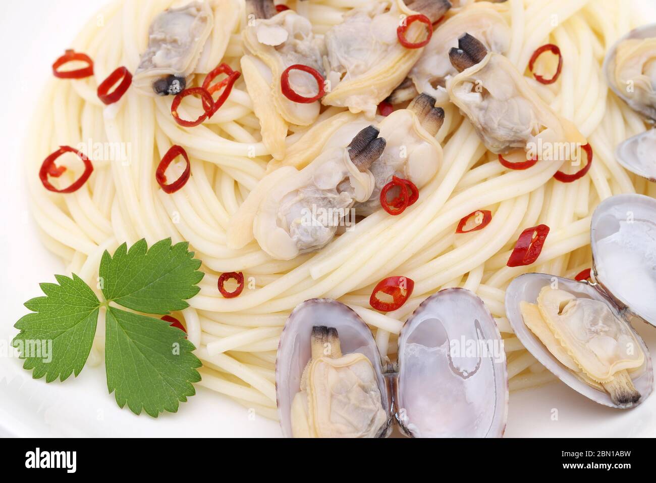 Primo piano degli spaghetti di vongole in un piatto su un tavolo di legno Foto Stock