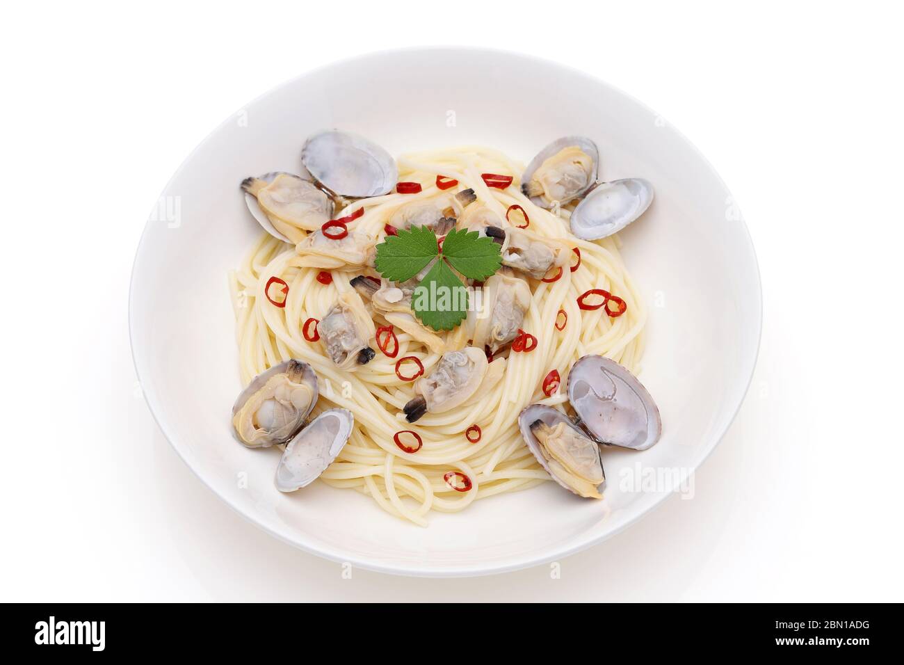 Primo piano degli spaghetti di vongole in un piatto su un tavolo di legno Foto Stock