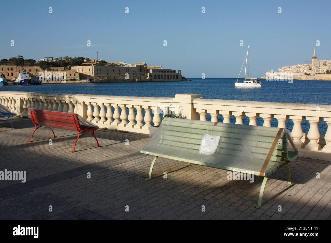 Coronavirus e COVID-19. Banchi pubblici coperti di teloni di plastica a Malta, in Europa, per imporre la distanza sociale. Impatto della pandemia sui viaggi. Foto Stock