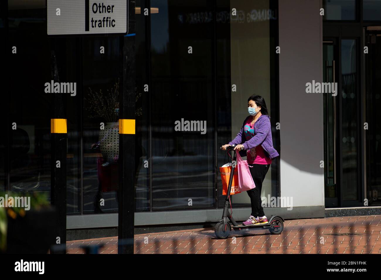 Una signora usa uno scooter nel centro di Birmingham, mentre il Regno Unito continua a fare il lock-down per contribuire a frenare la diffusione del coronavirus. Foto Stock