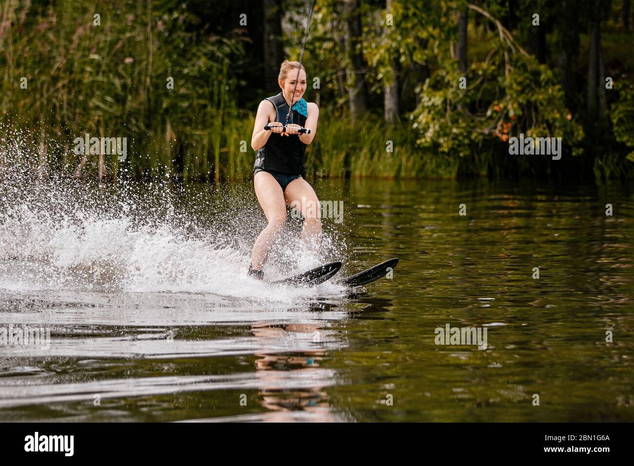 giovane donna in acqua sci equitazione sul lago in estate Foto Stock