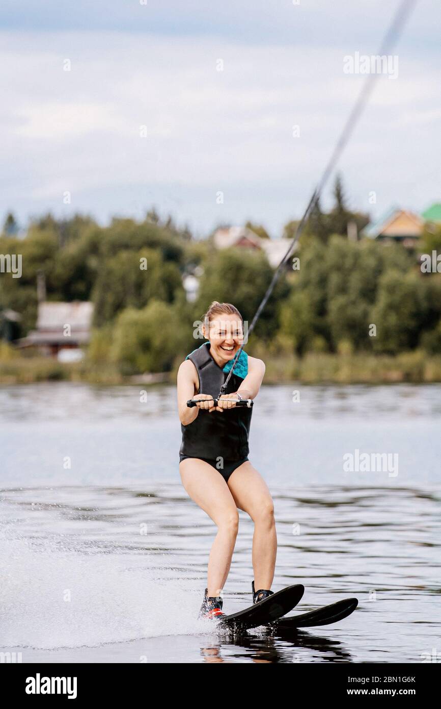 ragazza sorridente su sci d'acqua a cavallo sul lago Foto Stock