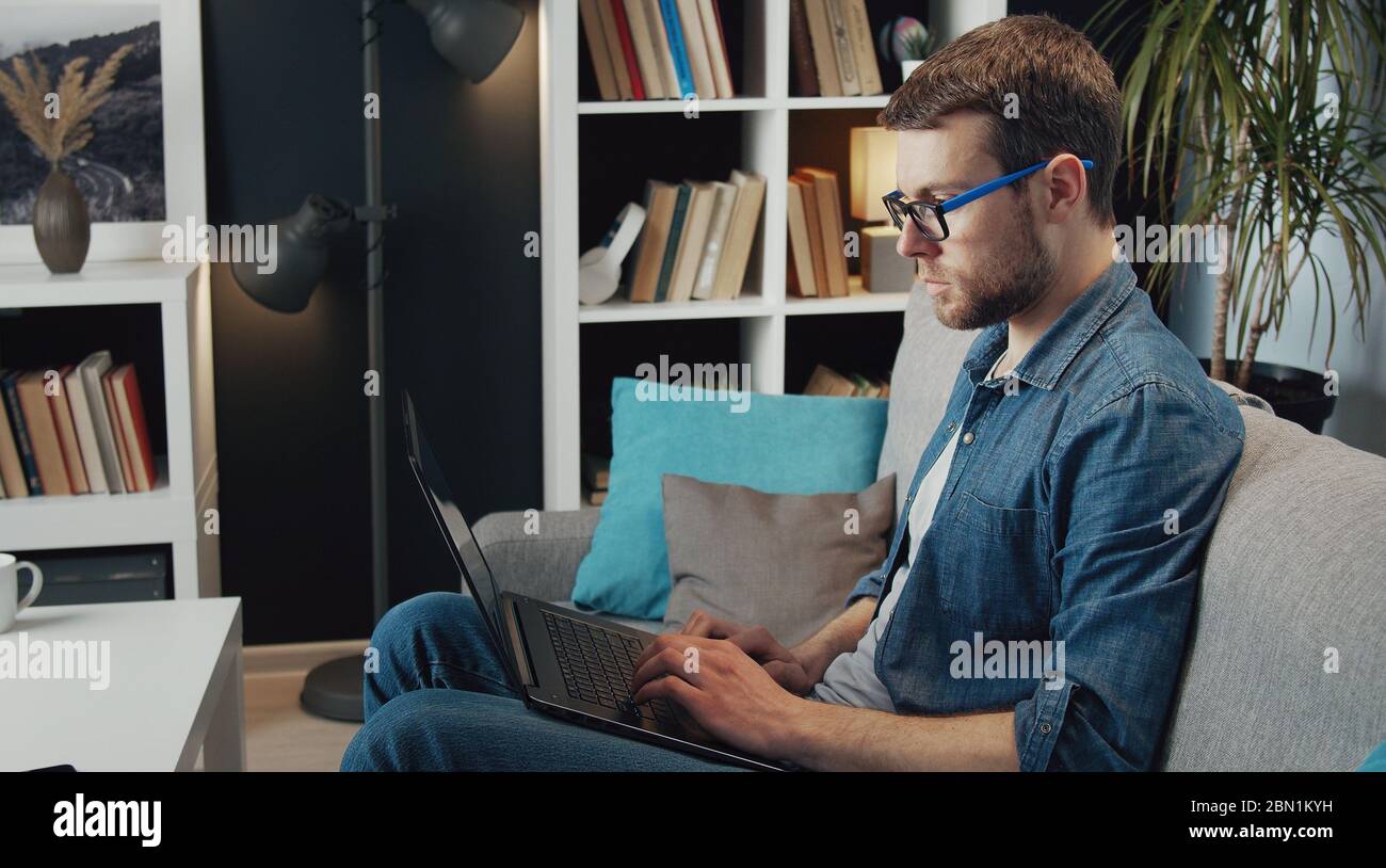 Uomo con notebook, vista laterale Foto Stock