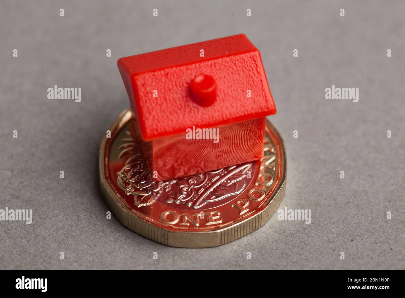 Casa rossa su una moneta inglese di una libbra. Concetto di prezzo della proprietà Foto Stock