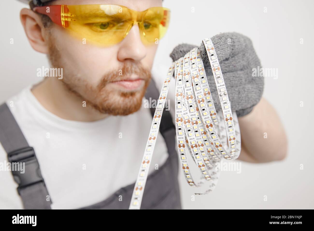 Elettricista che installa il nastro di montaggio striscia LED illuminazione decorativa. Foto Stock