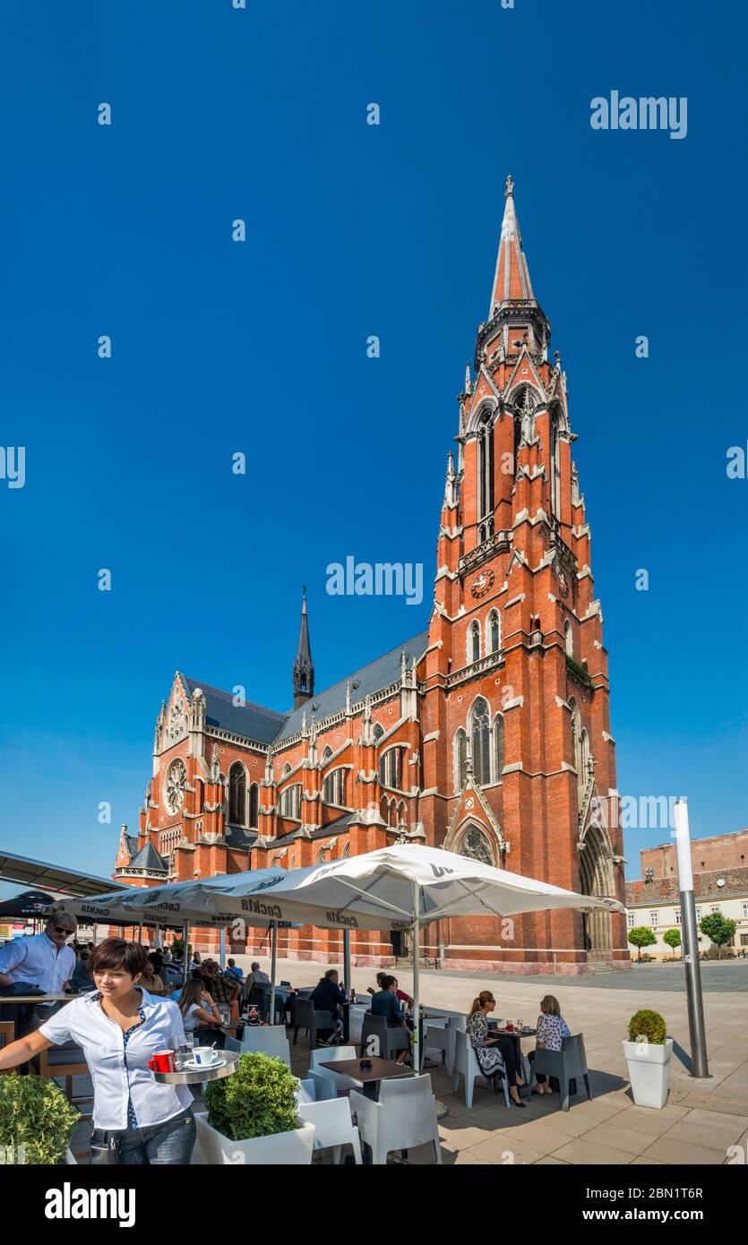 Sidewalk Cafe, Chiesa di San Pietro e San Paolo, la co-cattedrale cattolica romana, neo-gotica, a Osijek, Slavonia, Croazia Foto Stock