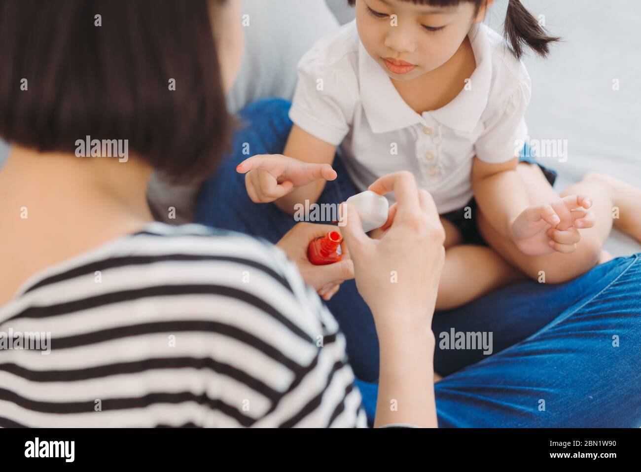 Madre e figlia in pigiama rendendo manicure a casa Foto Stock