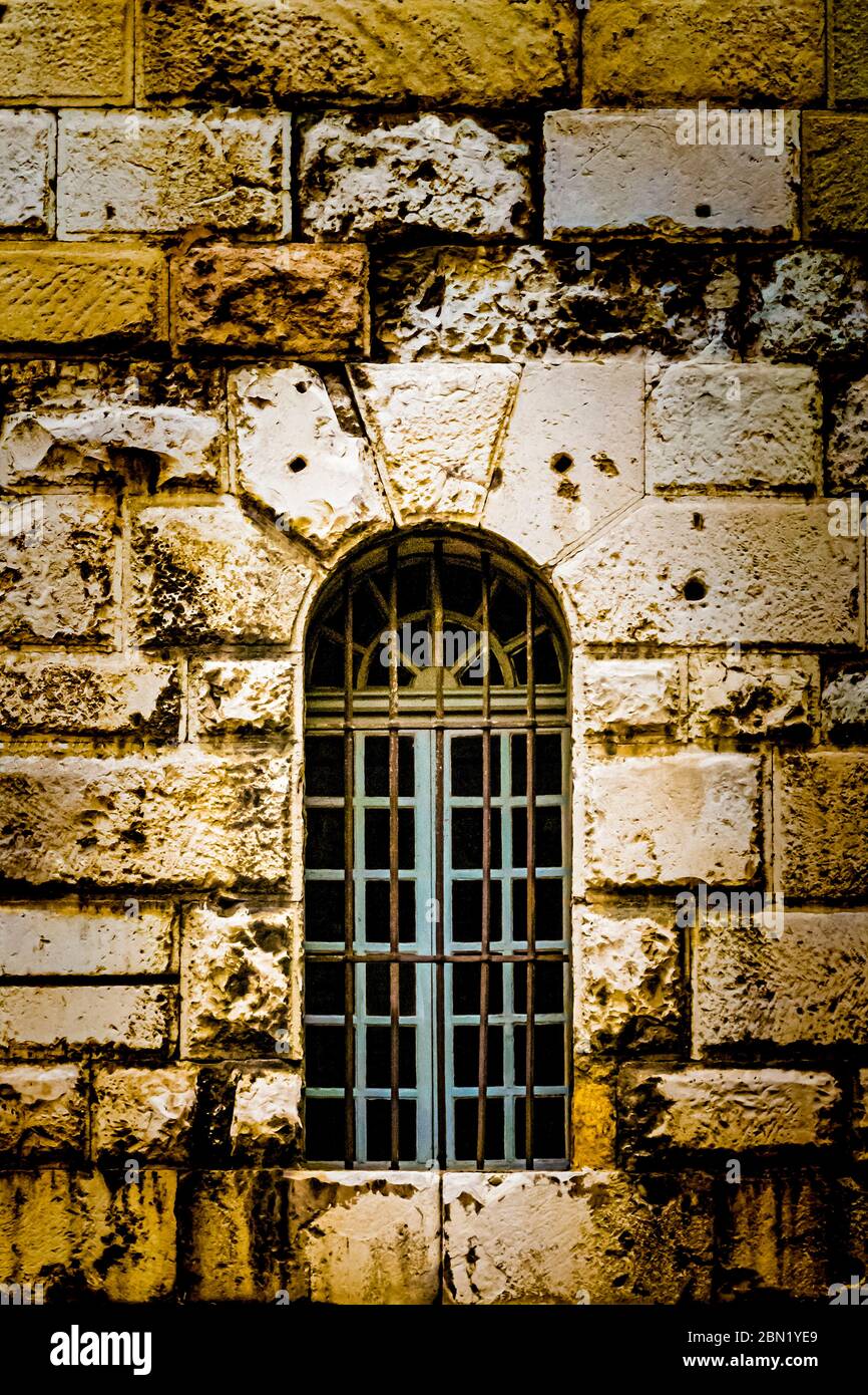 Strette finestre ad arco con barre di ferro in un edificio in pietra ad Aix en Provence, Francia Foto Stock