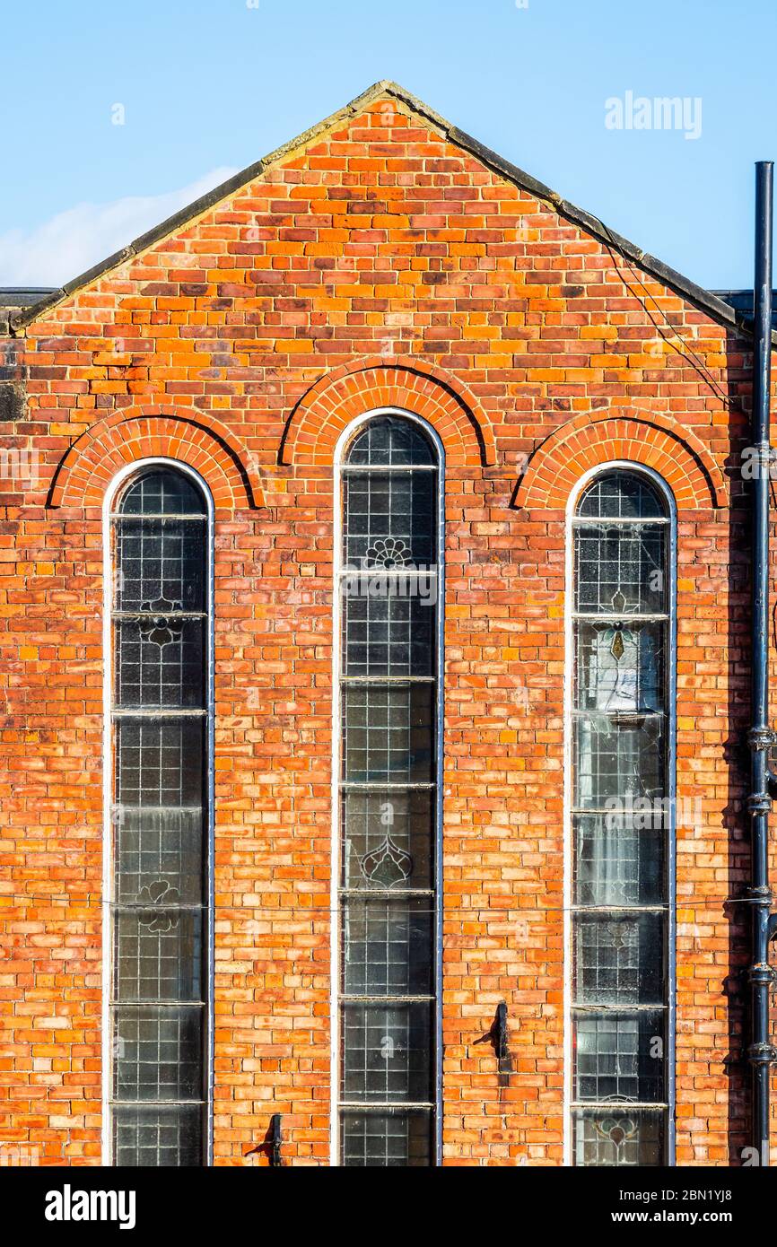 Edificio abbandonato in mattoni con tre alte e strette finestre, a Hexham, Northumberland, Regno Unito Foto Stock